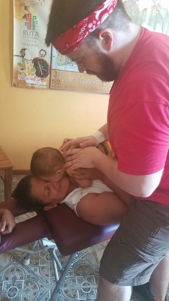 Kids and Chiropractic: Dr. Nathan adjusting a baby on a mission trip to Nicaragua